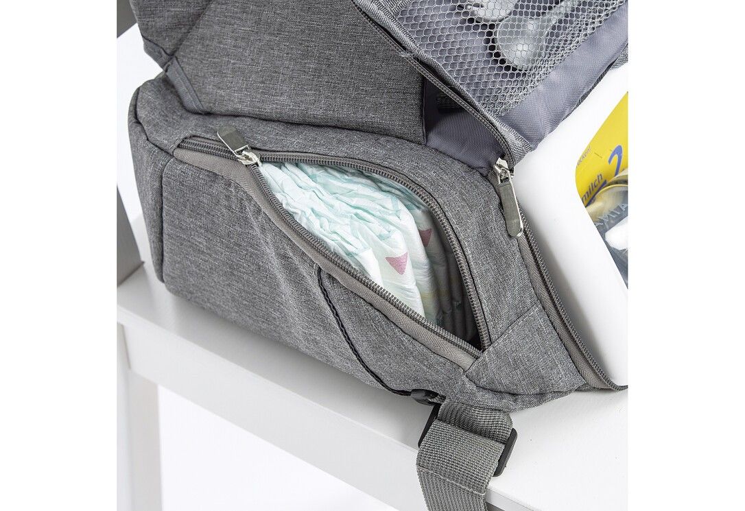 Nahaufnahme des grauen Sitzerhöhers. Reißverschluss an einer Tasche, Windeln sichtbar.