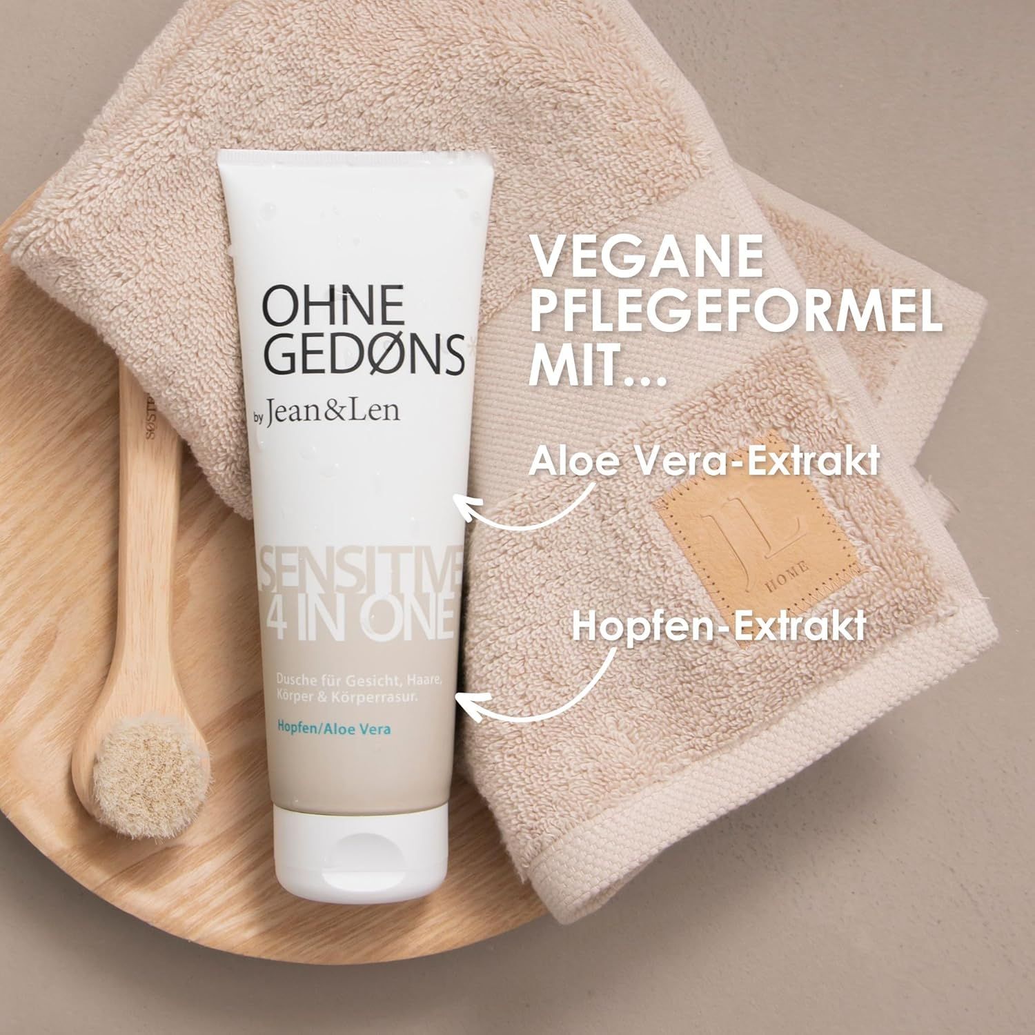 Tube OHNE GEDØNS by Jean & Len, Sensitive 4 in 1, auf Handtuch. Text: Vegane Pflegeformel mit... Aloe Vera-Extrakt, Hopfen-Extrakt.