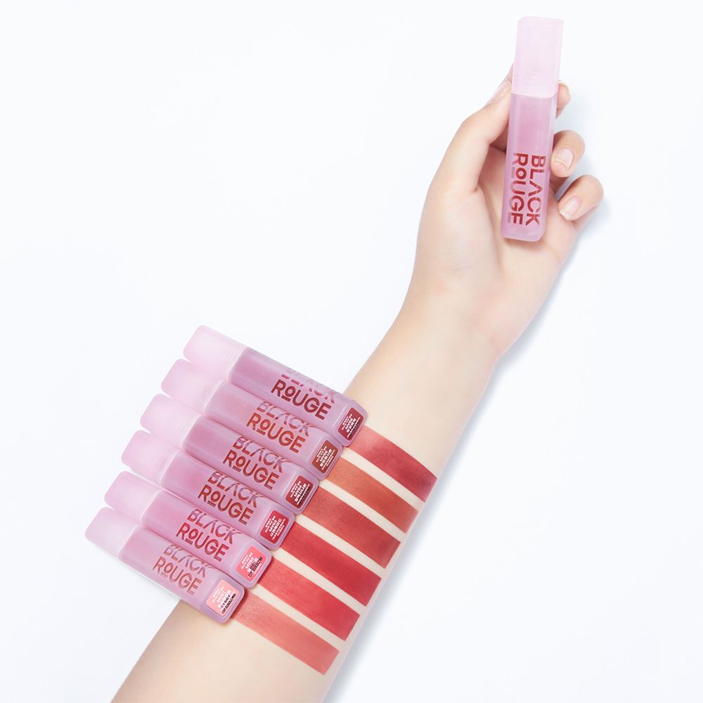 Hand mit Lippenstiften und Farbmustern auf dem Arm. Der Schriftzug BLACK ROUGE ist sichtbar.