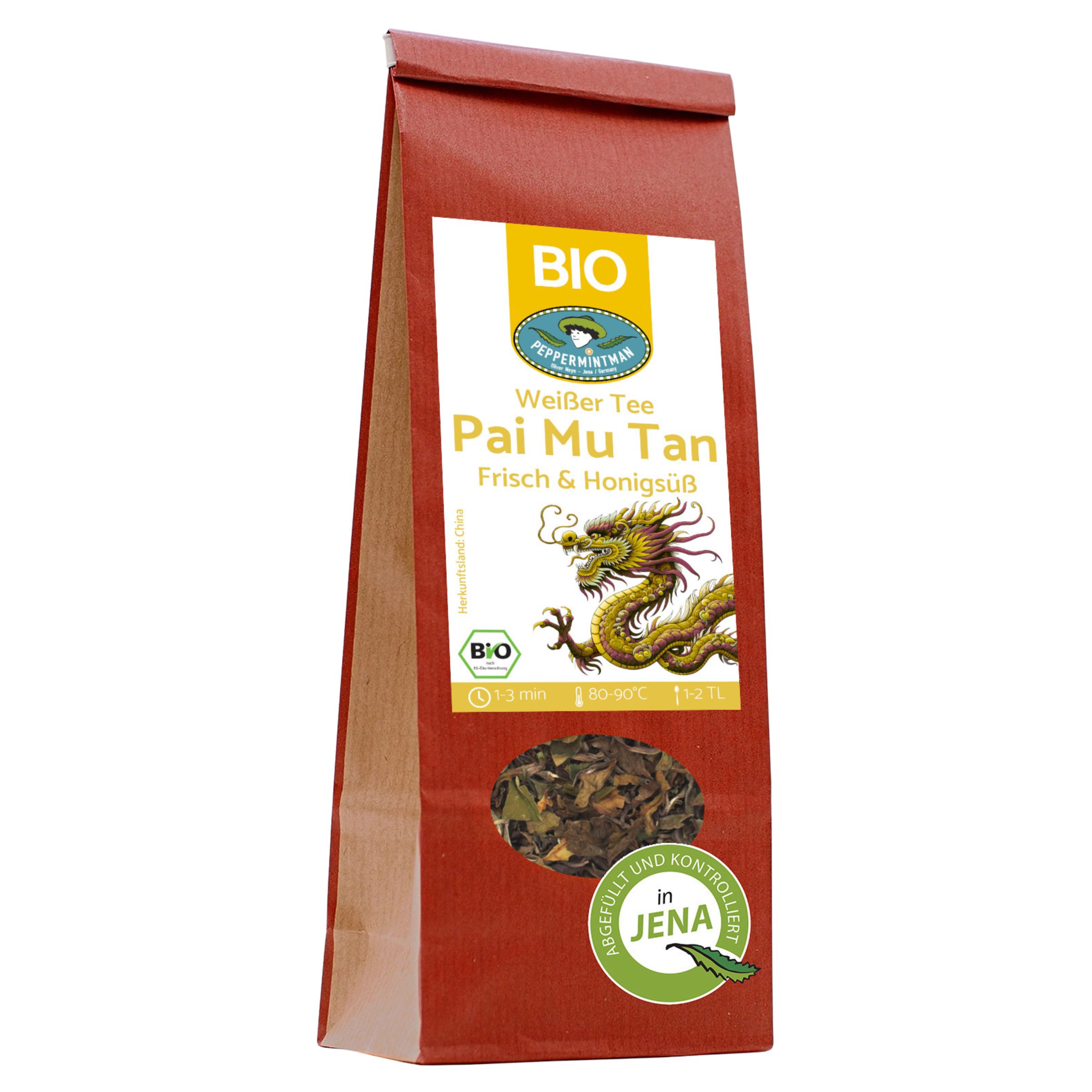 Braune Papiertüte mit weißem Etikett. Aufschrift: Weißer Tee Pai Mu Tan, Bio. Sichtfenster mit Teeblättern. Siegel.