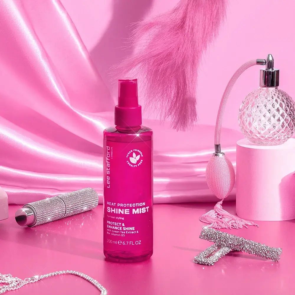Lee Stafford Hitzeschutz Glanzspray arrangiert mit dekorativen Elementen auf rosa Untergrund.