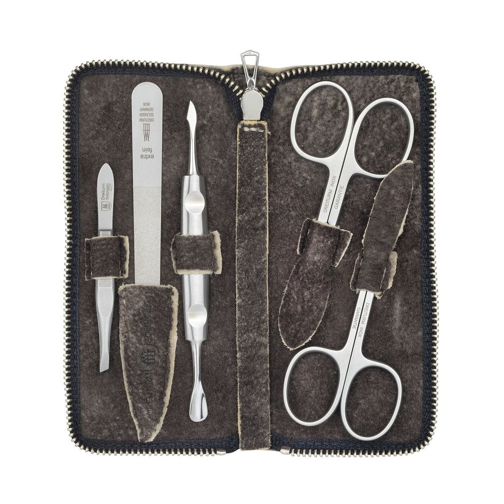 Maniküre-Etui aus Wildleder, geöffnet. Enthält Nagelschere, Feile, Nagelknipser und weitere Instrumente. Reißverschluss.