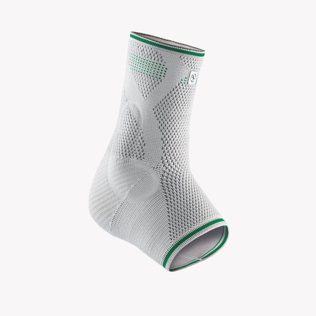 Knöchelbandage, weiß mit grünen Akzenten. Gestricktes Material. Grün umrandet. Perspektivische Ansicht.