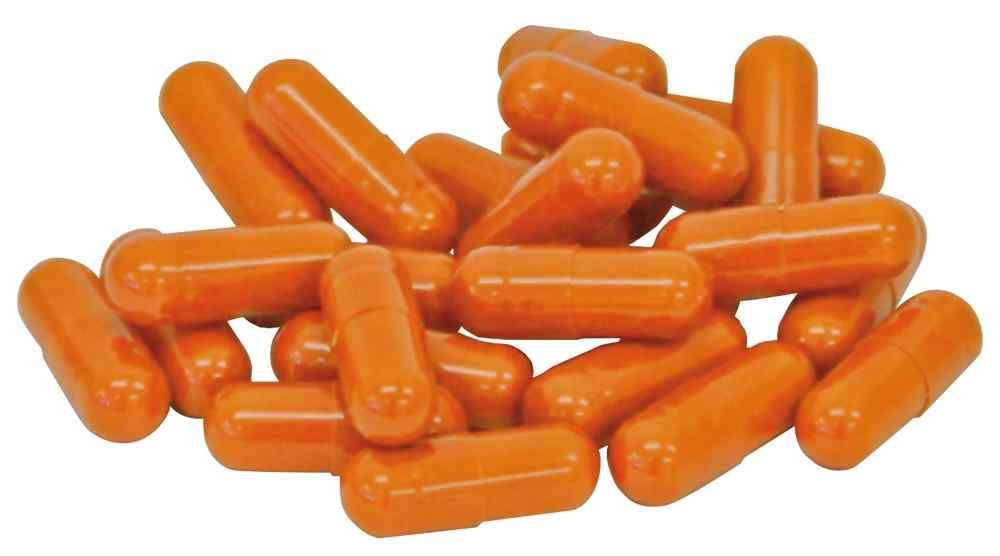 Haufen von ovalen, orangefarbenen Kapseln. Keine Verpackung sichtbar.