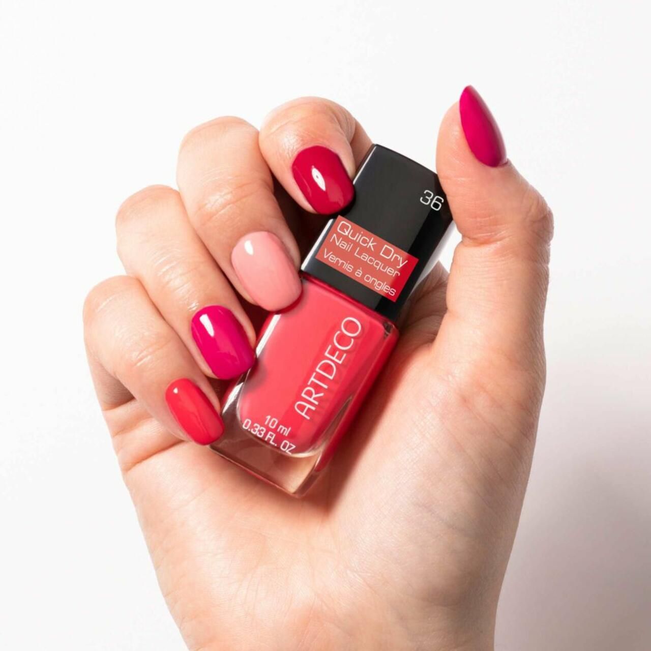 Hand hält Nagellackflakon und lackierte Nägel. Aufschrift: Quick Dry Nail Lacquer, Artdeco. Farbnummer 36.