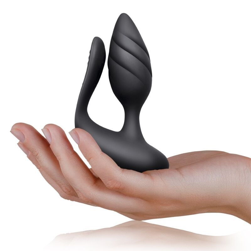 Schwarzes Wellness-Produkt, in Hand gehalten. Geformt mit einem geriffelten Kopf und geschwungenem Arm. Aus schwarzem Material.