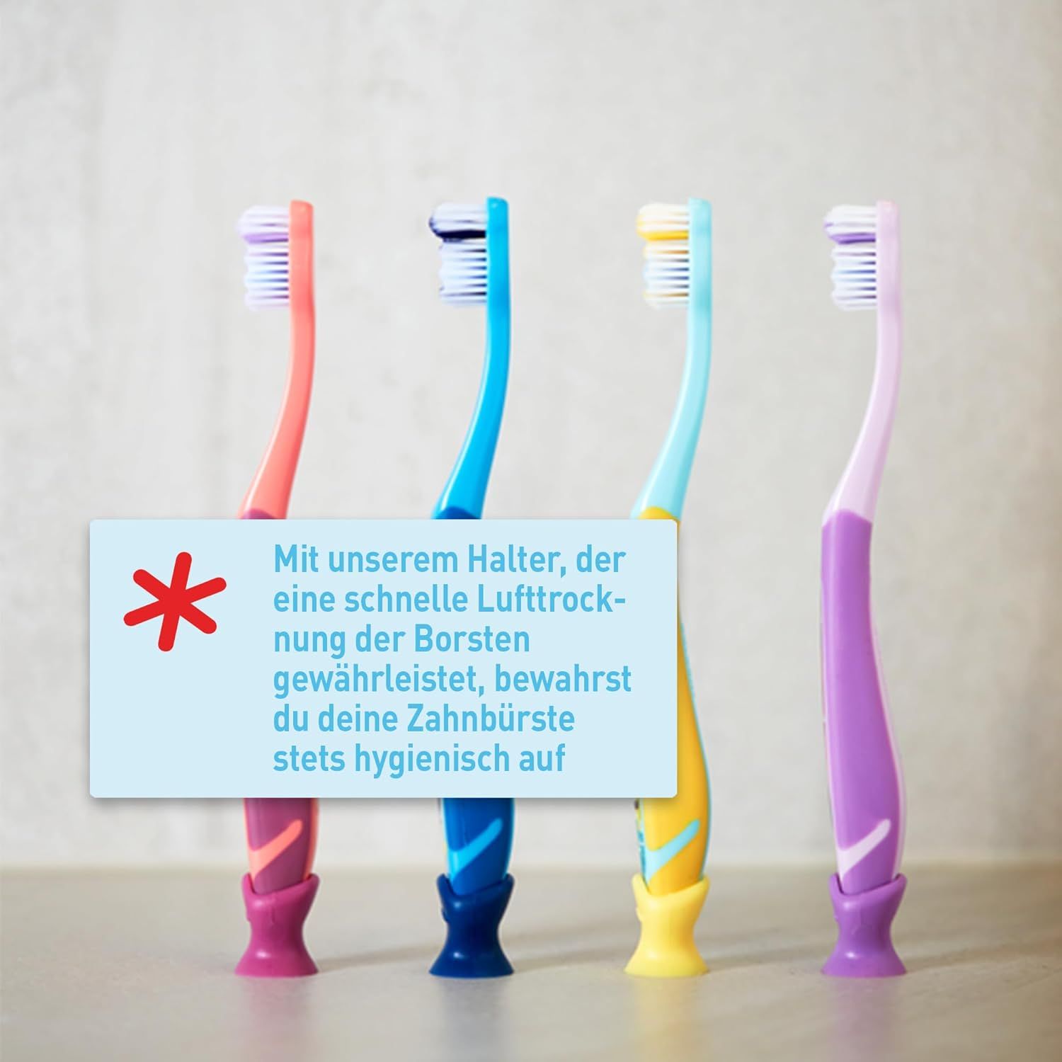 Vier Zahnbürsten mit farbigen Griffen. Rosa, blau, gelb und lila. Mit Halterung für Lufttrocknung der Borsten.