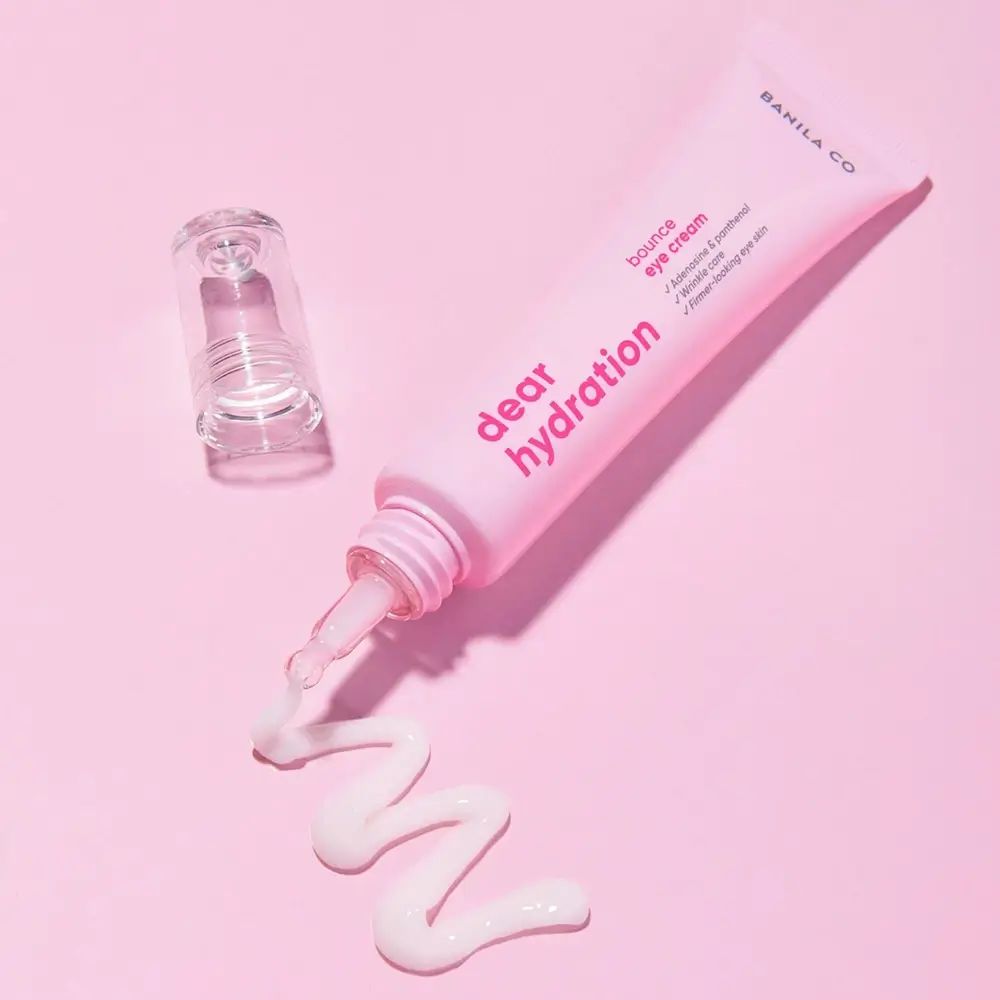 Rosa Tube Augencreme mit Applikator. Creme wird aus der Tube gedrückt.