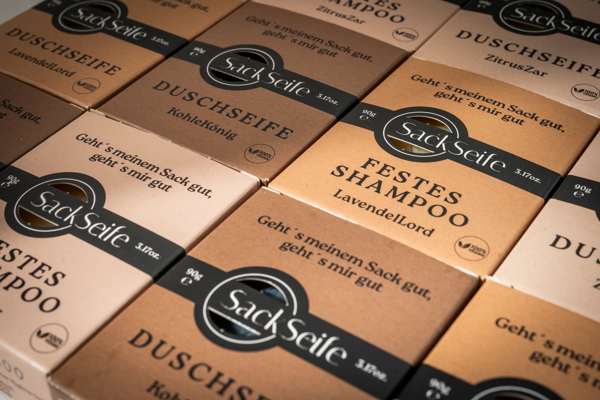 Mehrere Schachteln festes Shampoo. Verschiedene Sorten. Logo und Text auf den Verpackungen. Vegan-Siegel.
