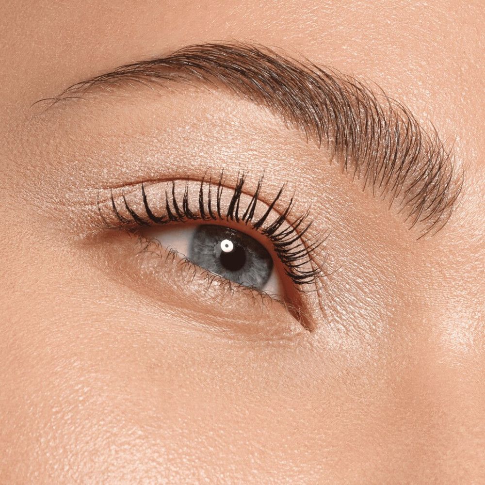 Nahaufnahme eines Auges mit Lidschatten und Wimperntusche. Das Auge ist blau und die Wimpern sind getuscht.