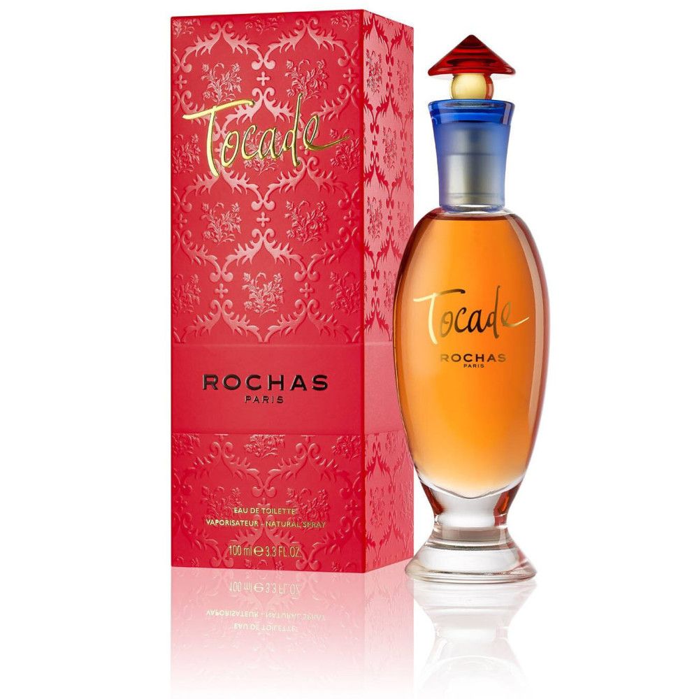 Parfümflasche mit roter Verpackung. Aufschrift "TOCADE" und "ROCHAS PARIS". Flakon mit blauem Hals und rotem Deckel.