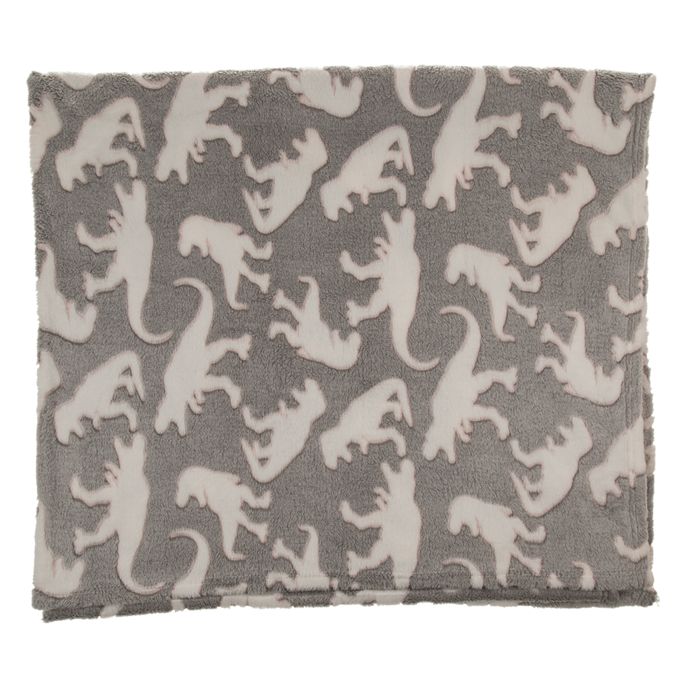 Graue Kuscheldecke mit weißen Dinosaurier-Mustern. Ausgebreitet, zeigt das Muster. Weiches Material.