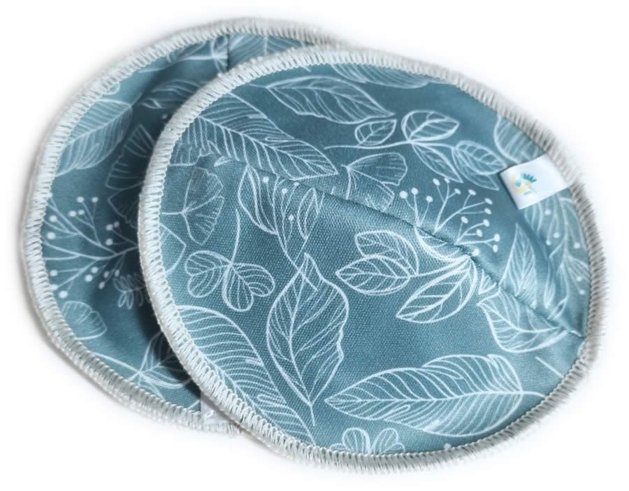 Zwei runde, blaue Stilleinlagen mit weißem Blättermuster. Weißer Rand und kleines Etikett.