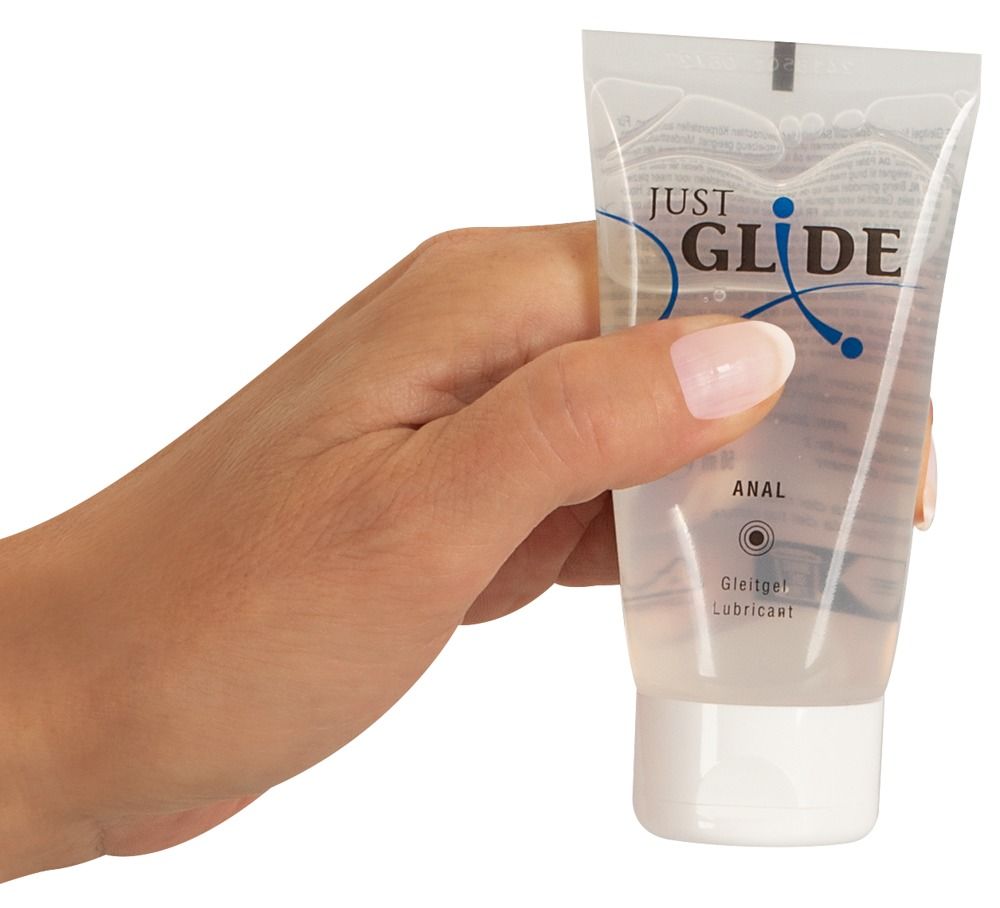 Hand hält Tube. Aufschrift: JUST GLIDE ANAL. Gleitgel. Lubricant. Transparentes Gel.