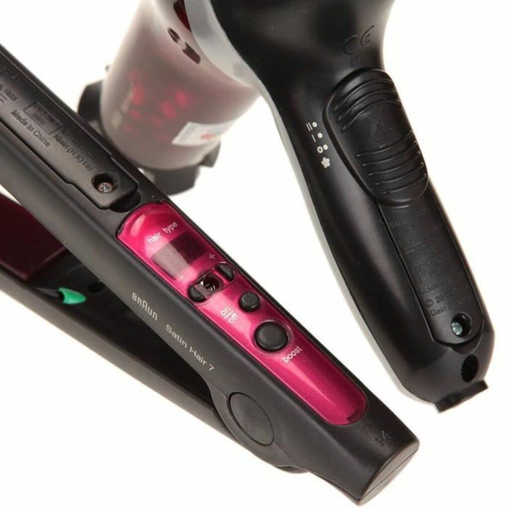 Nahaufnahme von Glätteisen und Haartrockner. Glätteisen mit Display und Knöpfen. Haartrockner mit Bedienelementen.