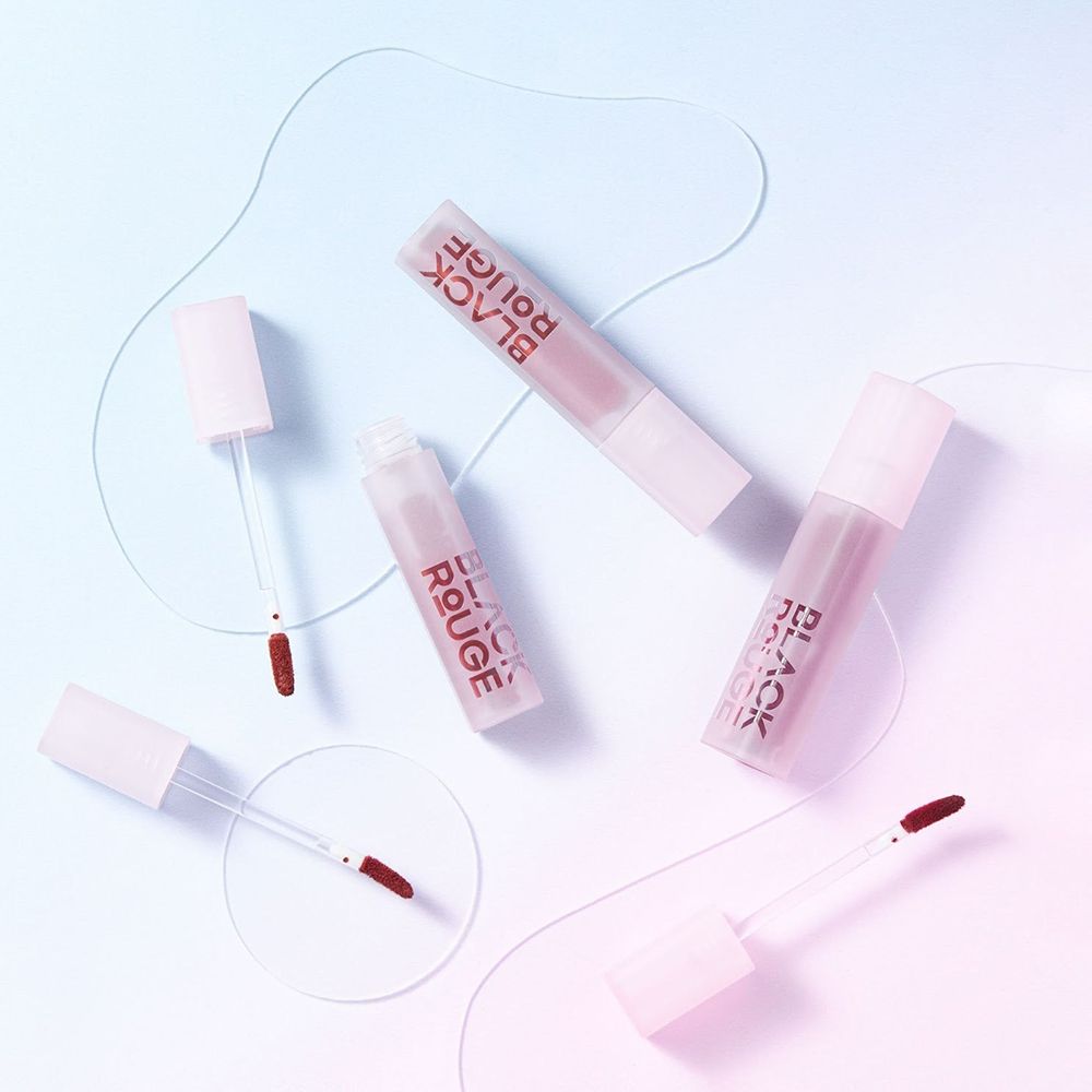 Mehrere Lippenstifte und Applikatoren auf einem farbigen Hintergrund. Die Lippenstifte sind rosa.
