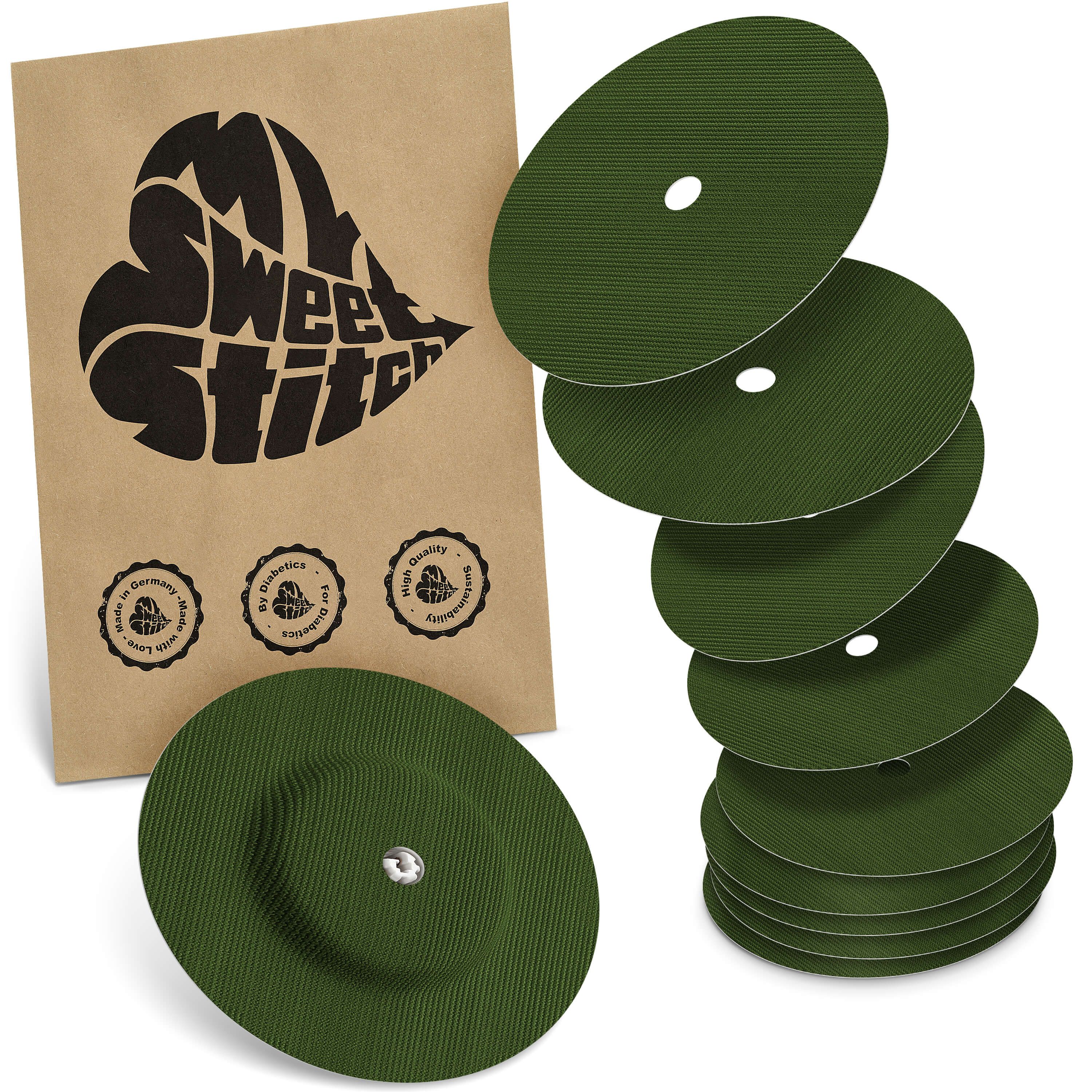 Grüne, runde Pflaster mit Loch und geriffelter Oberfläche. Verpackung mit Logo und Siegeln. Mehrere Pflaster liegen daneben.