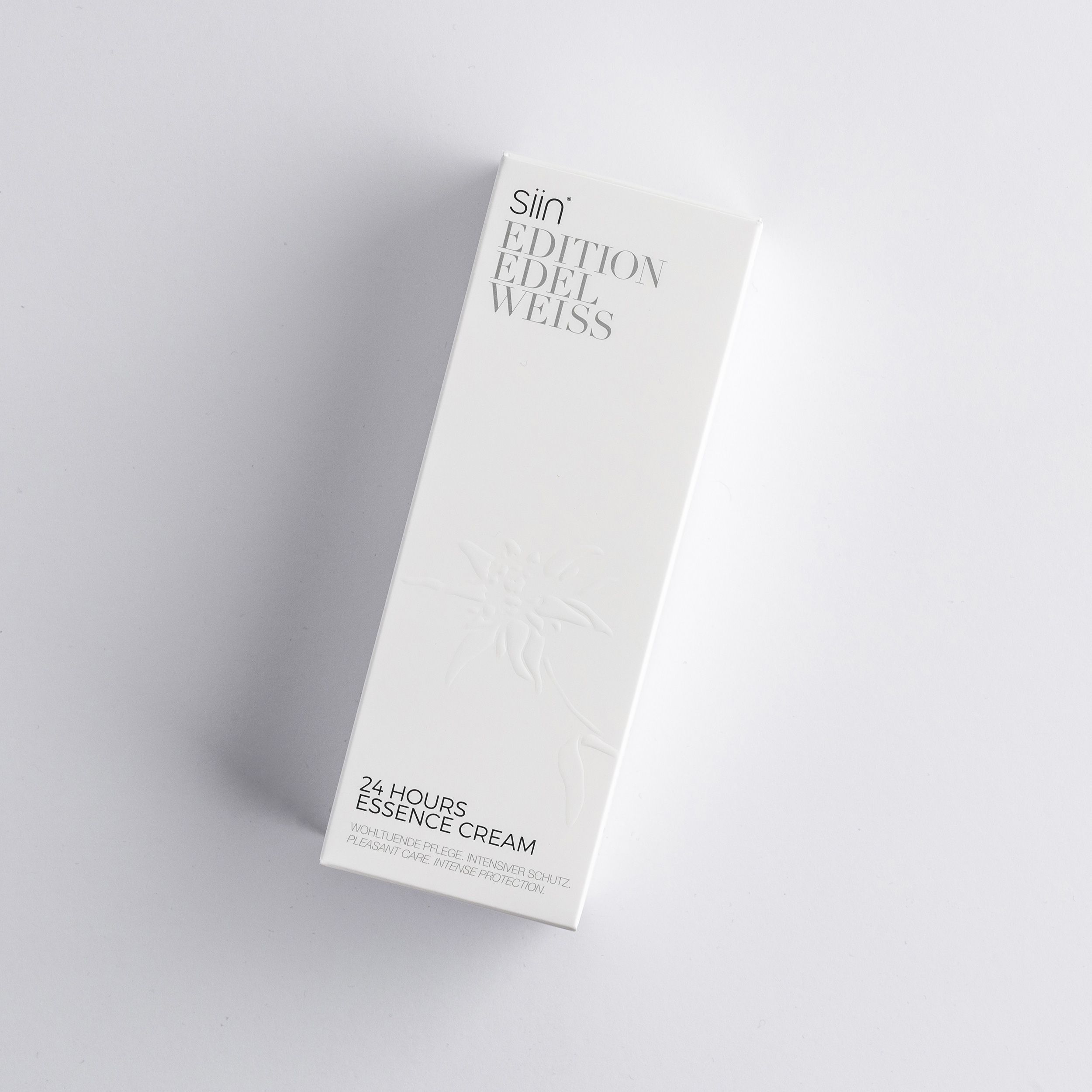 Weiße Produktverpackung mit Prägung und Text. Aufschrift: siin EDITION EDELWEISS, 24 HOURS ESSENCE CREAM.