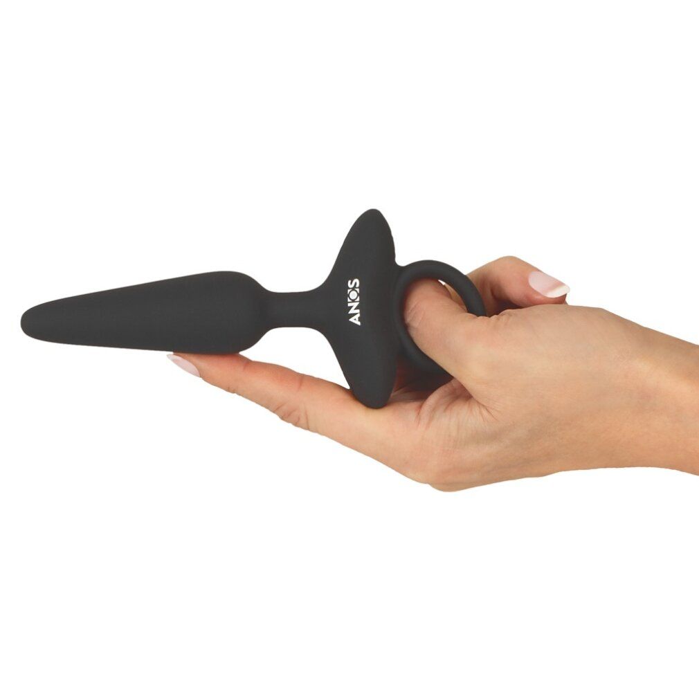 Schwarzer Analplug aus Silikon. Ringförmiger Griff, gehalten in einer Hand. Auf dem Produkt steht "ANOS".