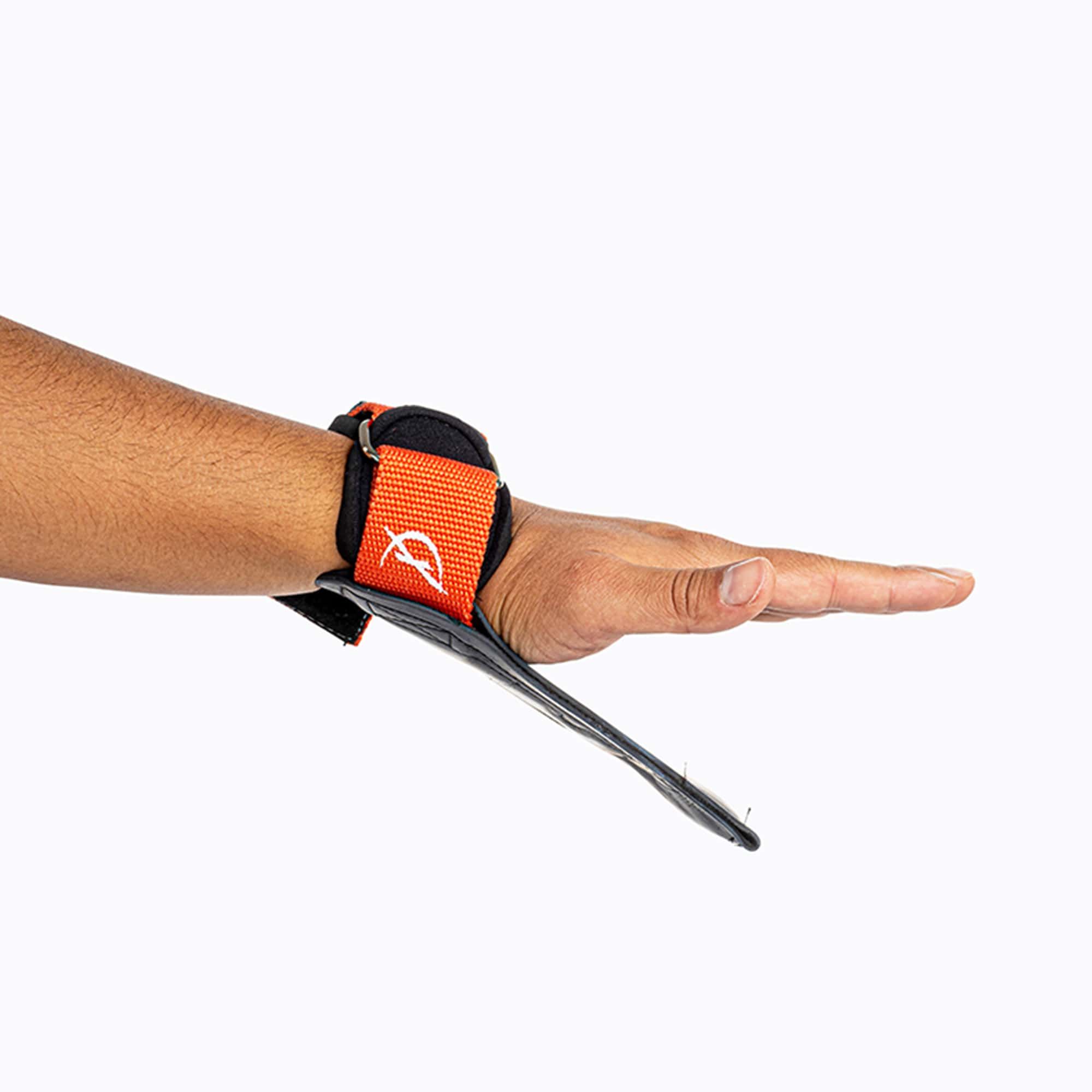 Hand mit Ultra Grip am Handgelenk. Schwarzes Band mit orangefarbenen Akzenten und "ULTRA GRIPS".
