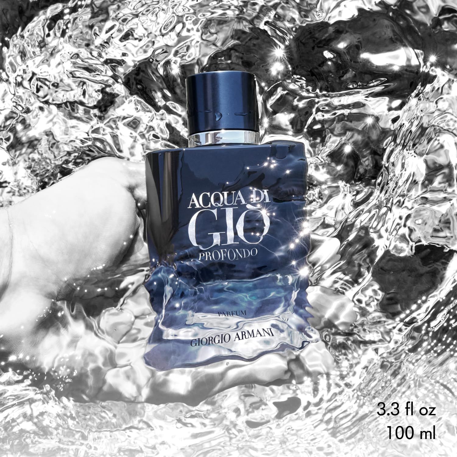 Dunkelblaue Flasche Acqua di Giò Profondo Parfum im Wasser. Silberner Deckel. Wellen und Reflexionen.
