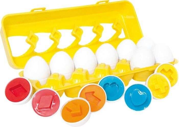 Gelbe Eierbox mit 12 weißen Eiern und farbigen Steckformen. Formen: Pfeil, Herz, Kreuz, Quadrat, Raute. Kunststoff.