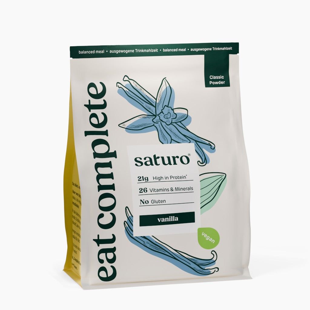 Beutel mit Saturo Trinkmahlzeit Vanille. Aufdruck: 21g Protein, 26 Vitamine & Mineralien, glutenfrei, vegan. Abbildung von Vanilleblüten.