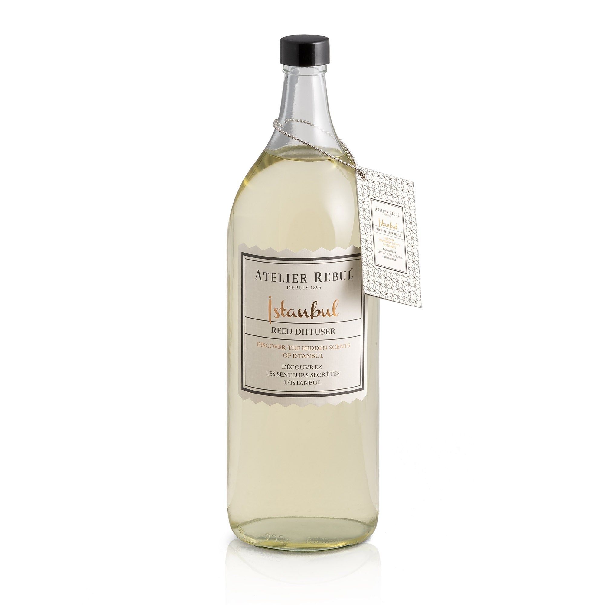 Große Glasflasche mit Etikett "Atelier Rebul Istanbul". Ein Anhänger ist an der Flasche befestigt.