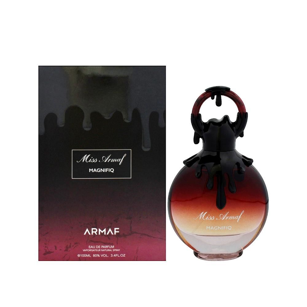 Parfümflasche und Verpackung. Flasche rund, rot-braun, mit schwarzem Deckel. Verpackung schwarz mit Schriftzug.