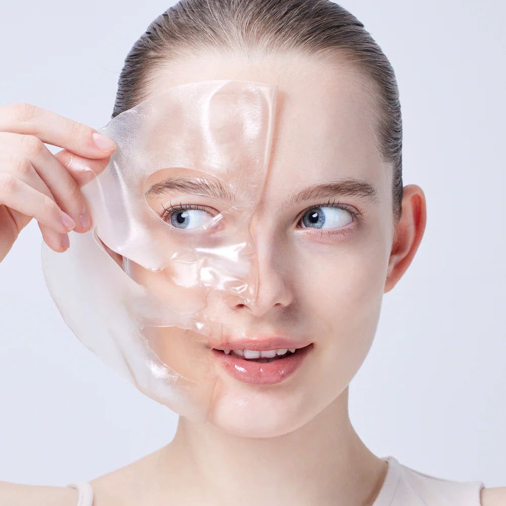 Frau entfernt eine Hydrogel-Maske vom Gesicht. Nahaufnahme.