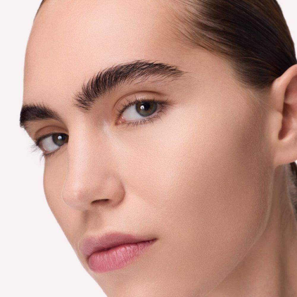 Nahaufnahme eines Gesichts. Geformte Augenbrauen. Hautton: hell. Lippenstift: rosa.