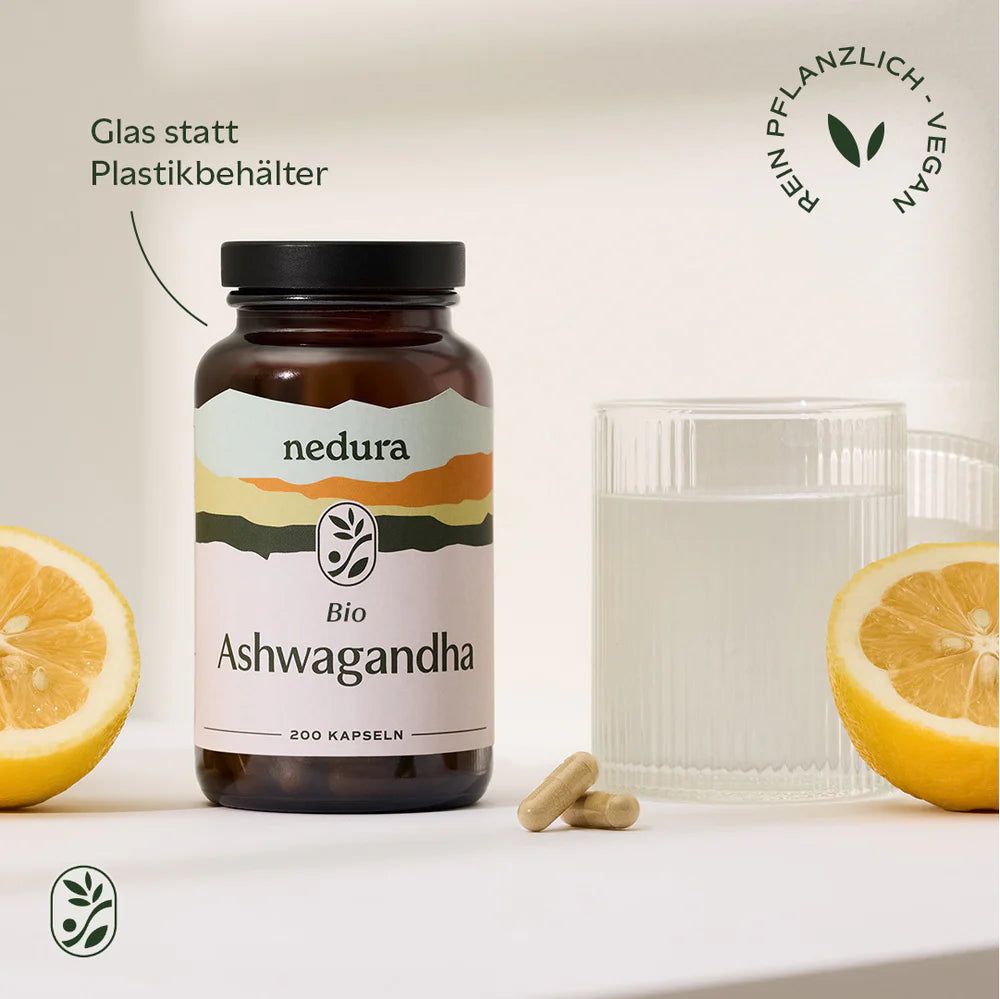 Braune Glasflasche "nedura bio Ashwagandha" mit Kapseln, Glas Wasser, Zitrone. Text: "Glas statt Plastikbehälter".