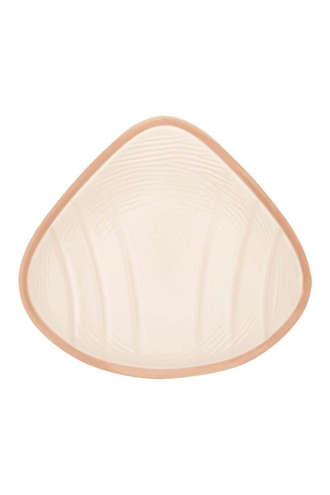 Brustprothese, Innenseite. Beige mit geriffelter Oberfläche und braunem Rand.