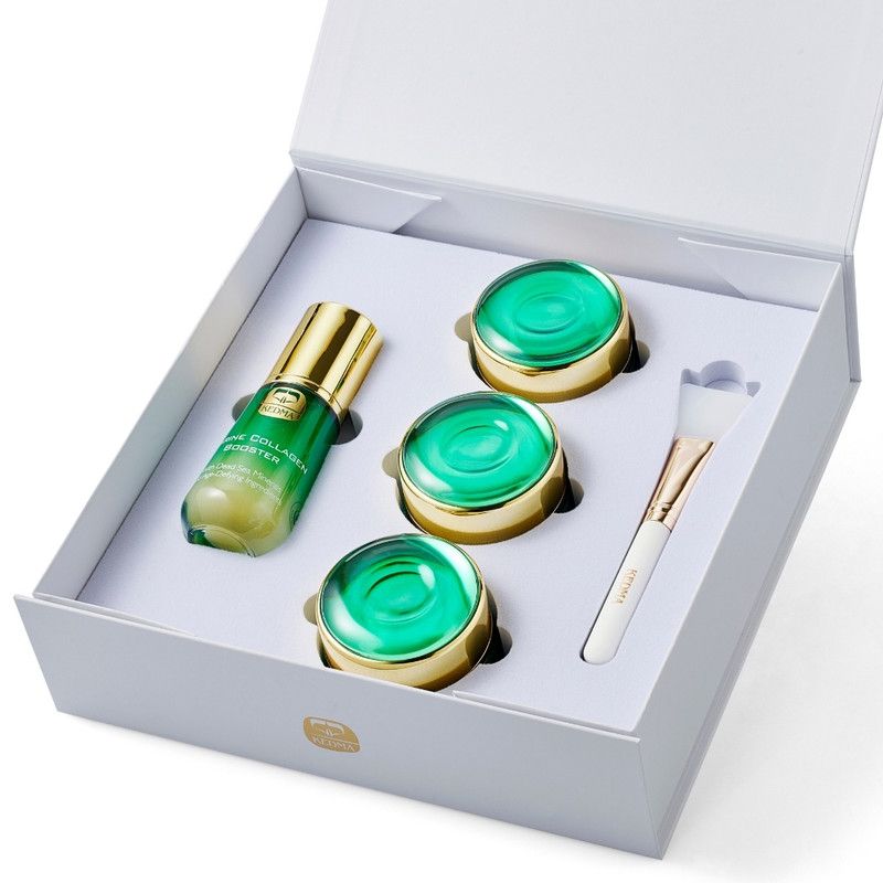 Pflegeset in weißer Box. Enthält Serum, drei Tiegel mit grüner Creme und einen Pinsel. Goldfarbene Deckel und Akzente.