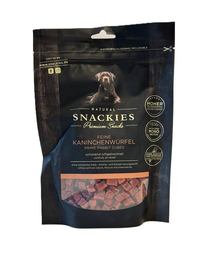 Verpackung mit Kaninchenwürfeln. Schwarze Tüte mit Produktnamen und Logo. Sichtfenster zeigt Würfel. Wiederverschließbar.