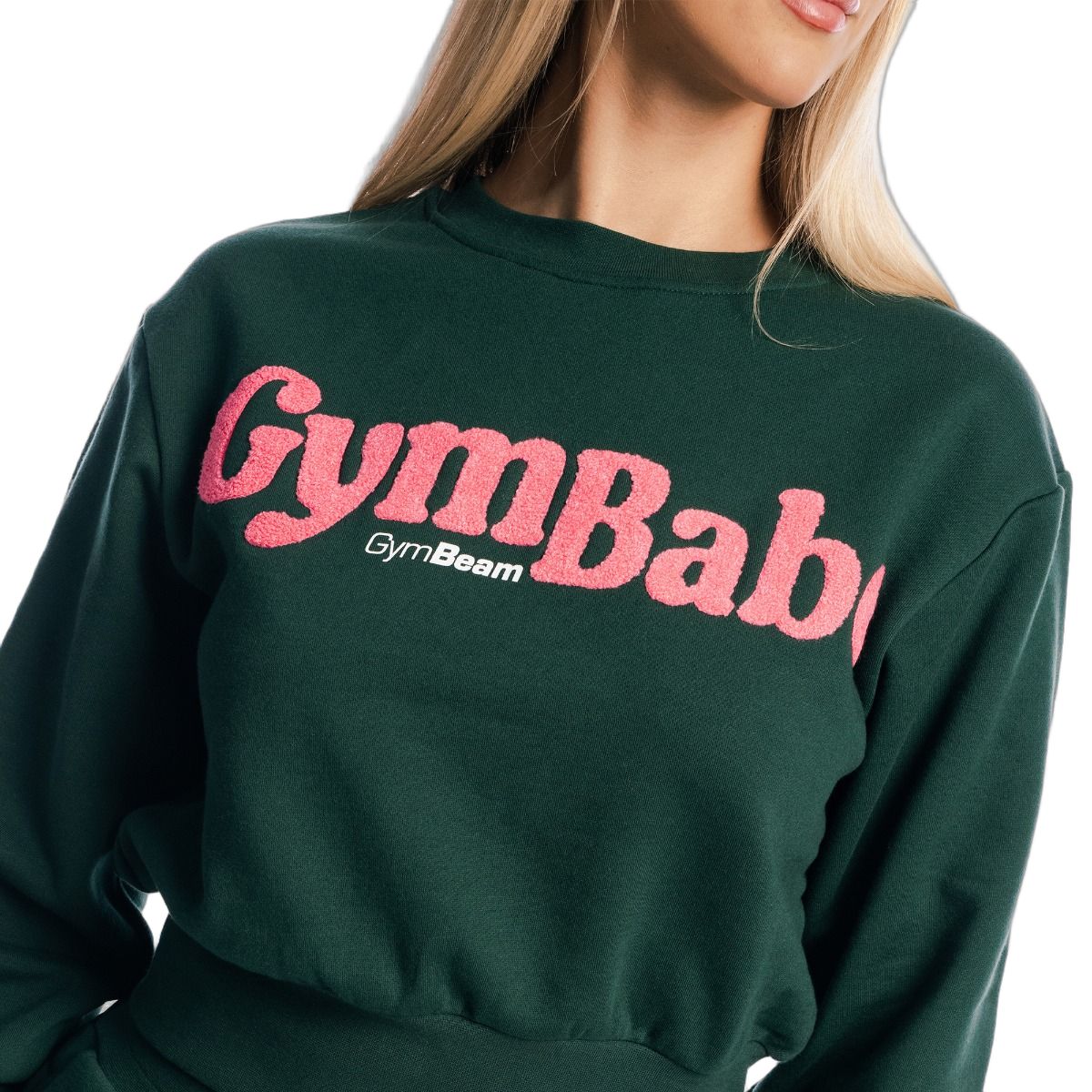 Nahaufnahme des rosa Schriftzugs 'GymBaby' auf einem grünen Damen Pullover cropped Langarm.
