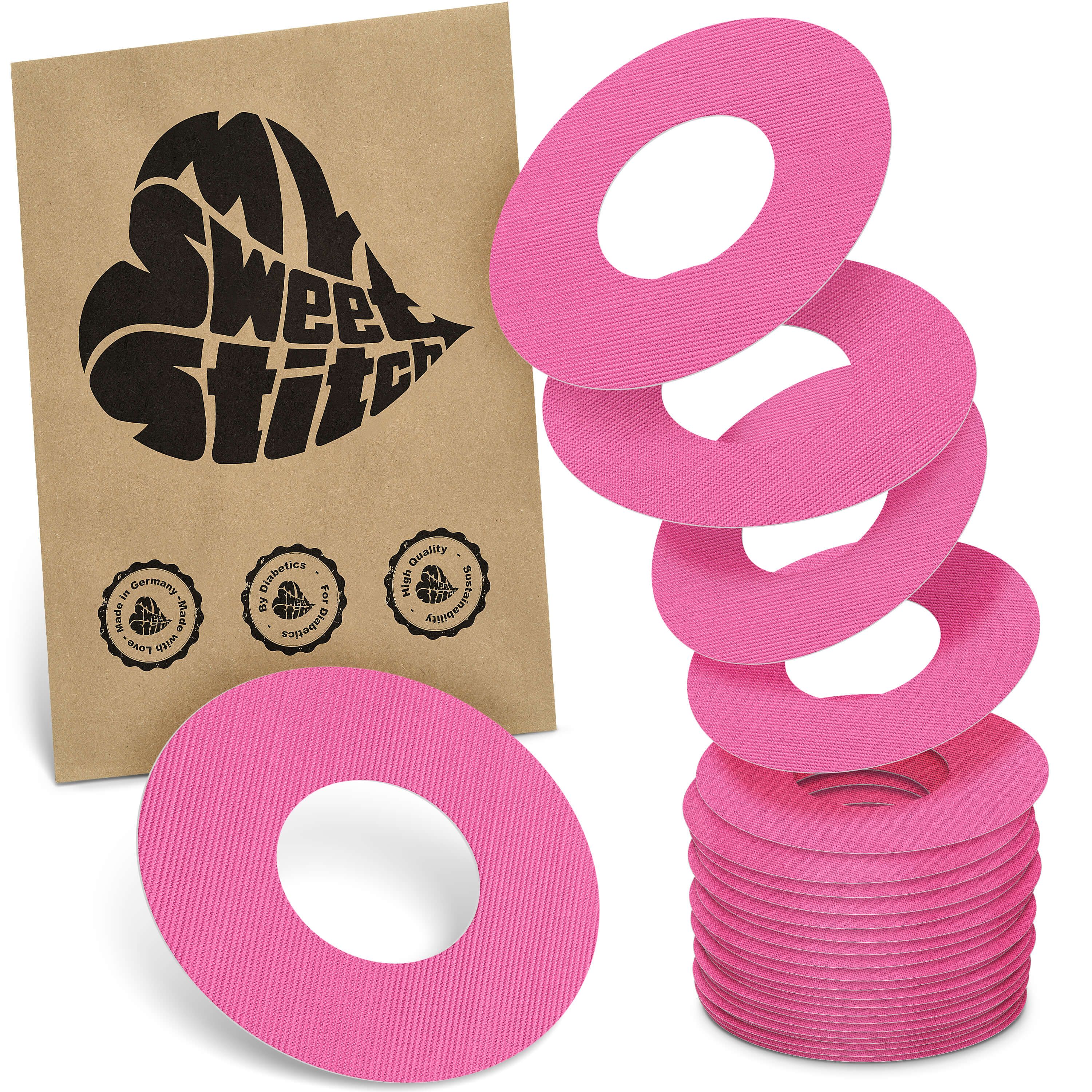 Rosa Fixierringe, gestapelt und in Papierverpackung mit Logo und Siegeln.