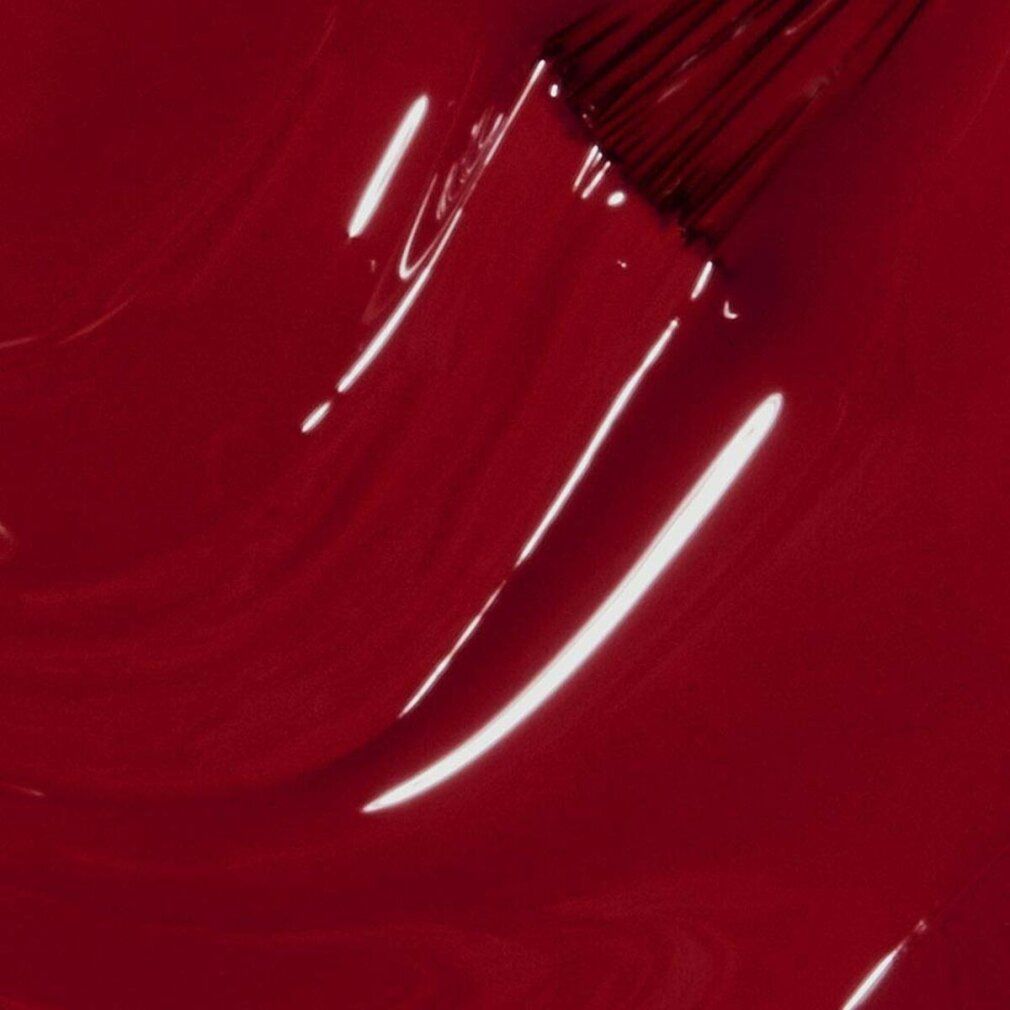 Nahaufnahme von rotem Nagellack. Pinselspuren im Lack. Glänzende Oberfläche. Rote Farbe.