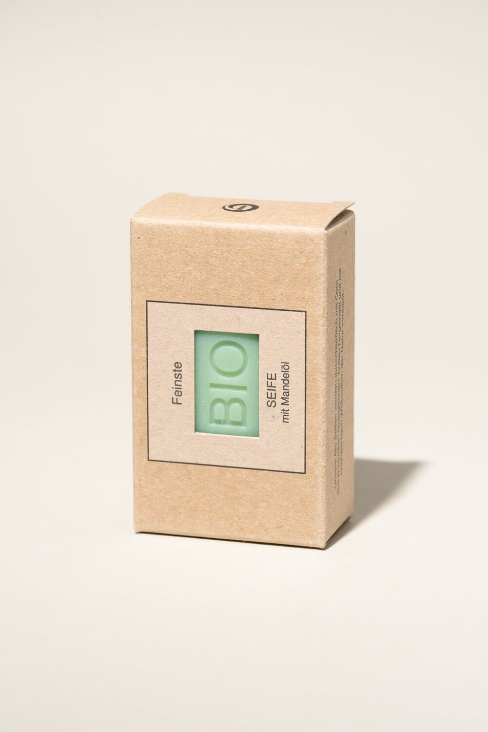 Seife in Kartonverpackung. Aufdruck: BIO SEIFE mit Mandelöl. Grünliche Seife in brauner Verpackung.