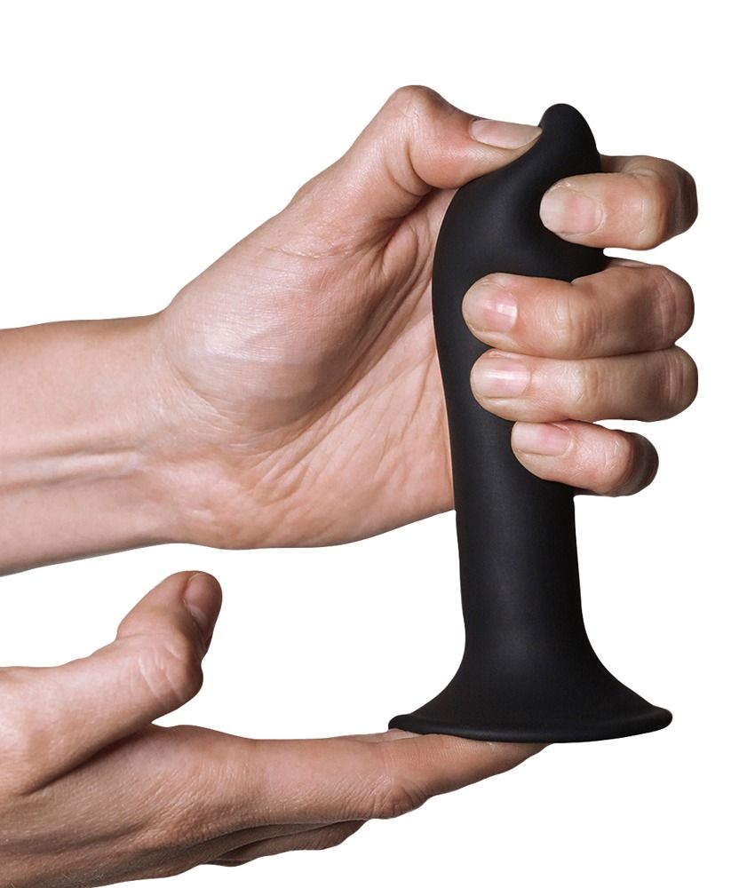 Schwarzer Dildo in Hand gehalten. Der Dildo hat eine breite Basis und eine geschwungene Form.