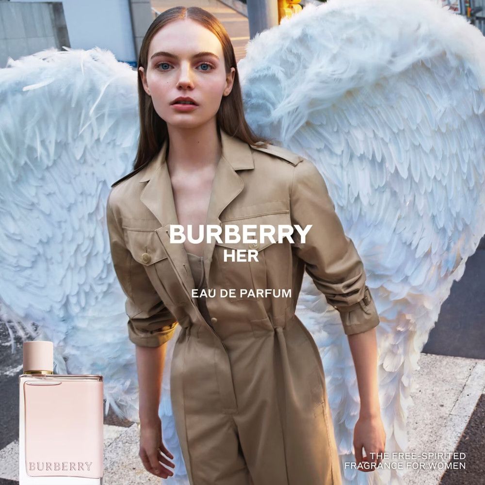 Frau mit Flügeln und Burberry Her Eau de Parfum-Flakon. Aufschrift: Burberry Her Eau de Parfum.