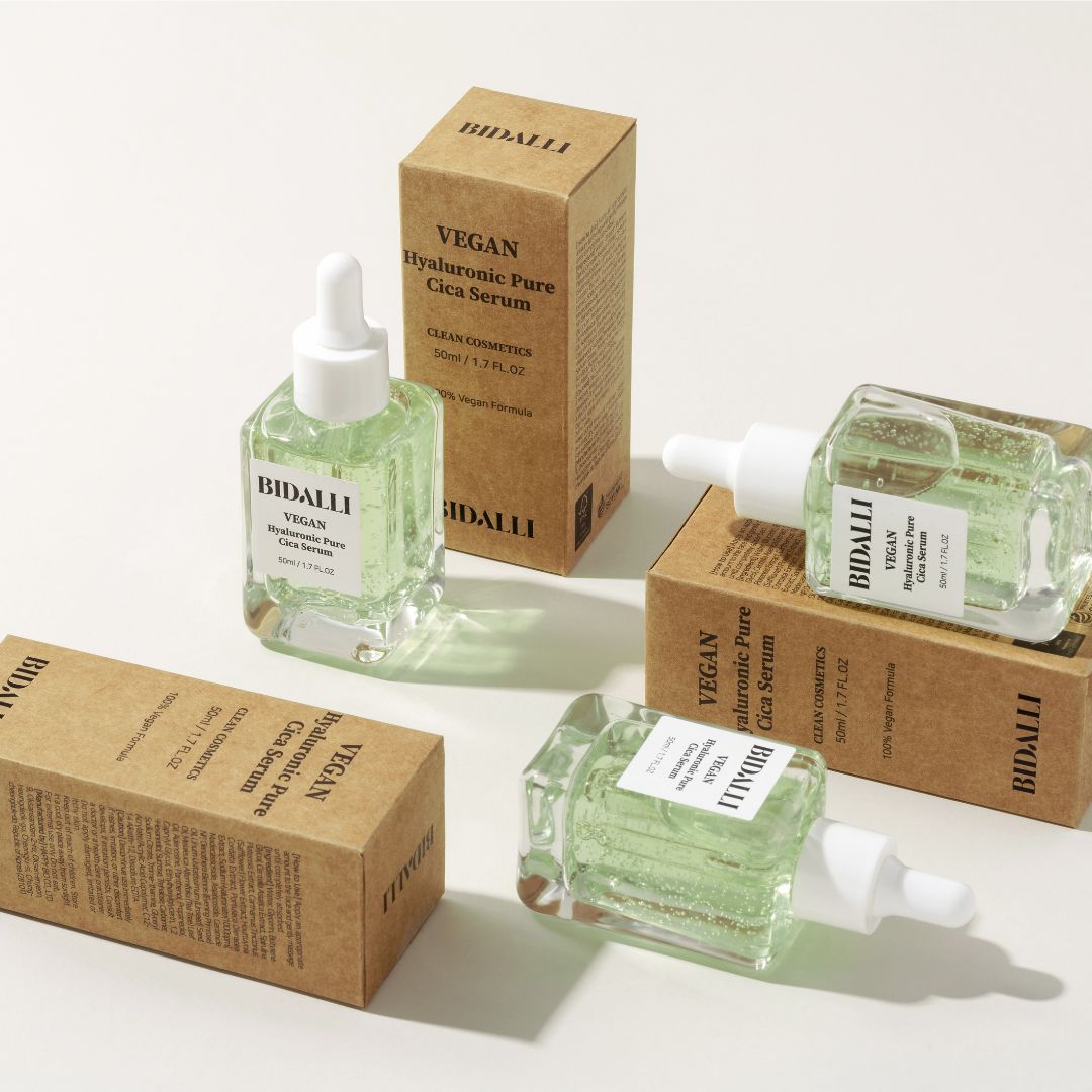 Mehrere Flaschen und Kartons. Auf den Flaschen steht 'Bidalli Vegan Hyaluronic Pure Cica Serum'.
