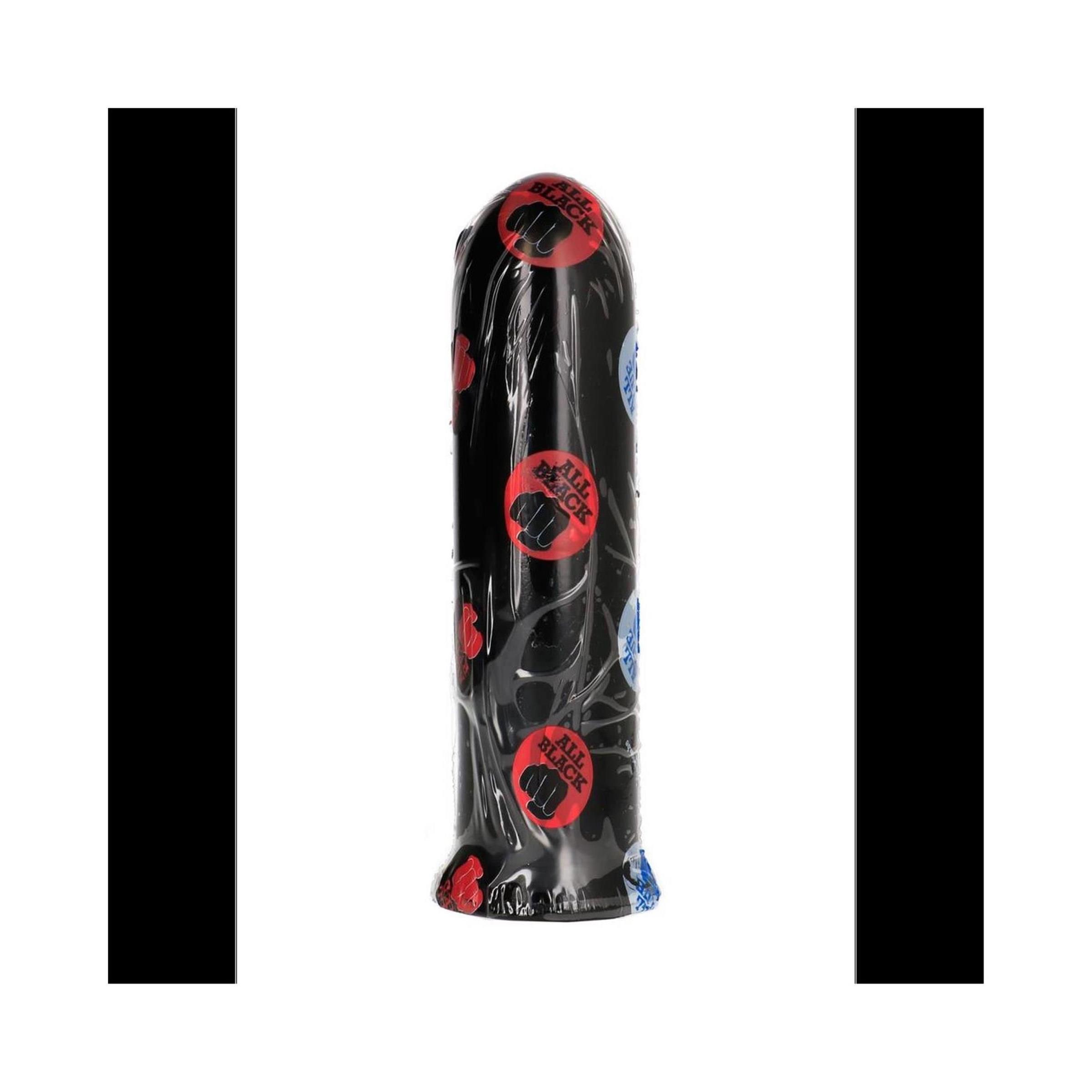 Schwarzer Dildo in Folie verpackt. Rote und blaue Aufkleber mit Logo. Zylindrische Form mit abgerundeter Spitze und breiter Basis.