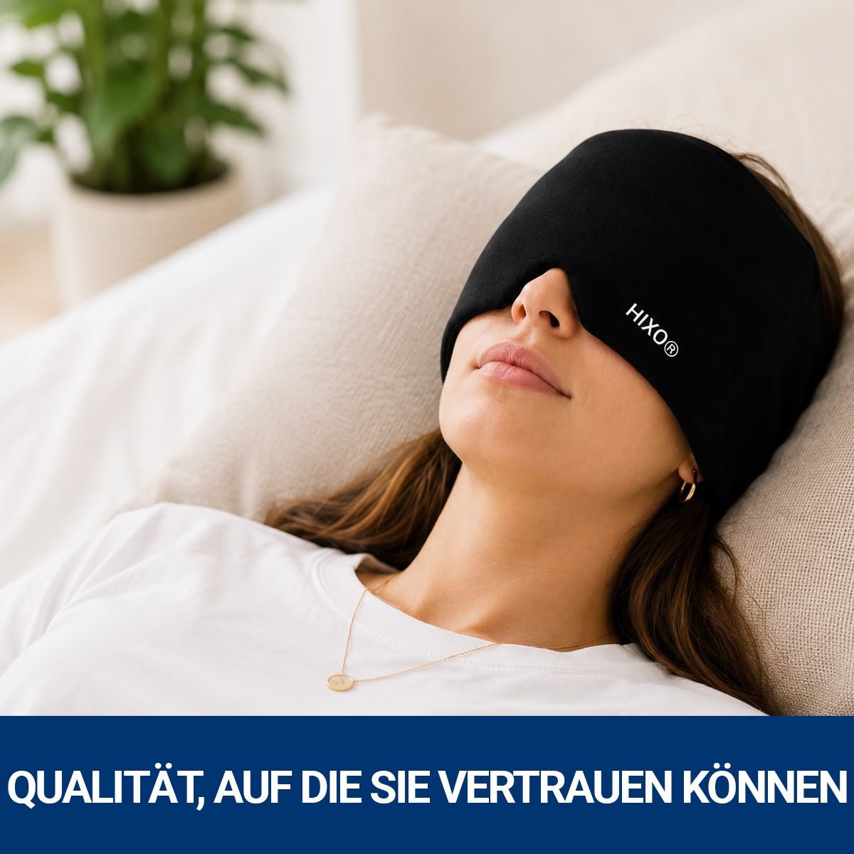 Frau mit geschlossenen Augen trägt eine schwarze HIXO Migräne Kühlmaske auf einem Sofa.