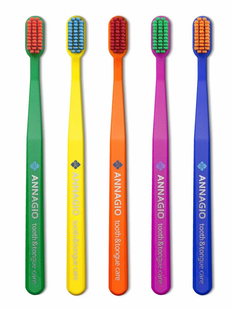 Fünf Zahnbürsten in Grün, Gelb, Orange, Lila und Blau mit farblich passenden Borsten. Logo und Text 'ANNAGIO tooth & tongue care' auf den Griffen.