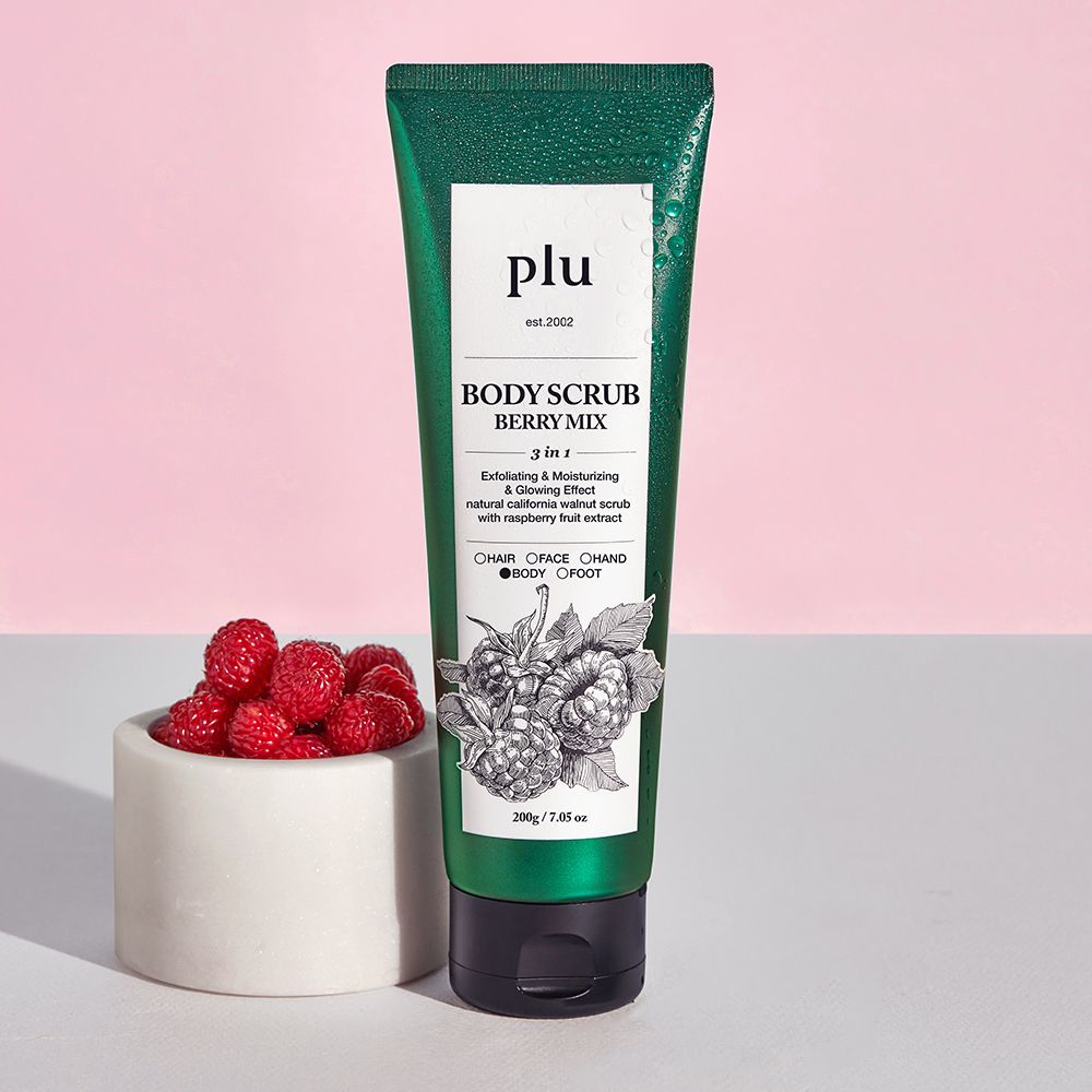 Grüne Tube mit schwarzem Verschluss. Aufschrift: PLU, Body Scrub Berry Mix. Illustration von Himbeeren. Daneben eine Schale mit Himbeeren.