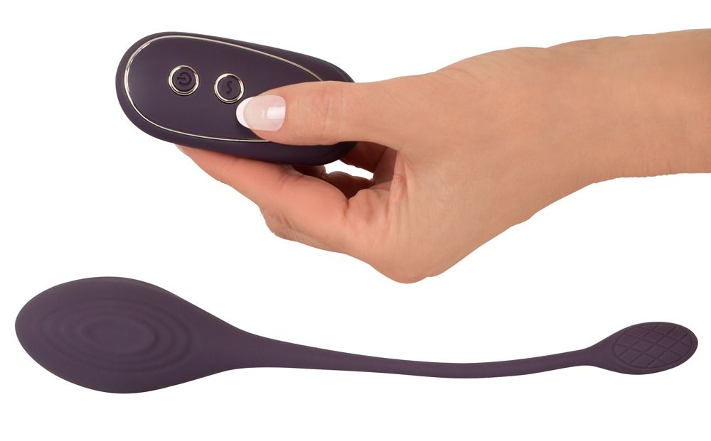 Hand hält Fernbedienung. Love Ball in länglicher Form. Lila Farbe mit geriffelter Oberfläche.