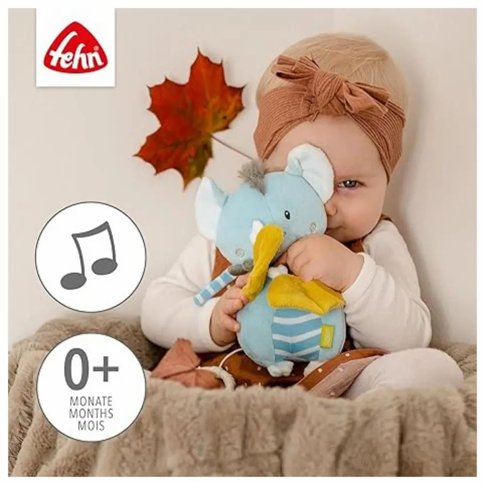 Baby hält Fledermaus-Spieluhr. Text: 0+ Monate. Logo Fehn. Notensymbol.