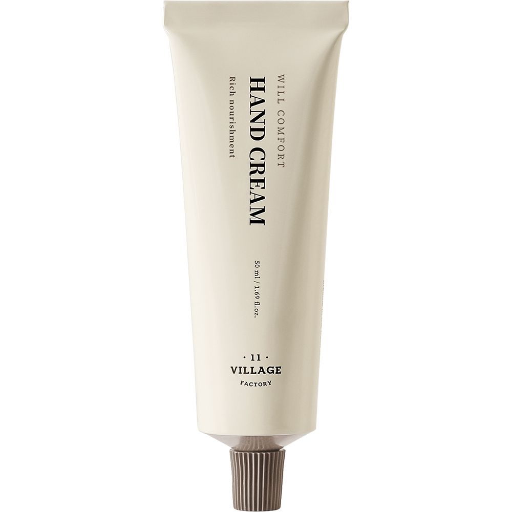 Creme-Tube. Aufschrift: WILL COMFORT, HAND CREAM, Rich nourishment, VILLAGE FACTORY. Beige Tube mit braunem Verschluss.