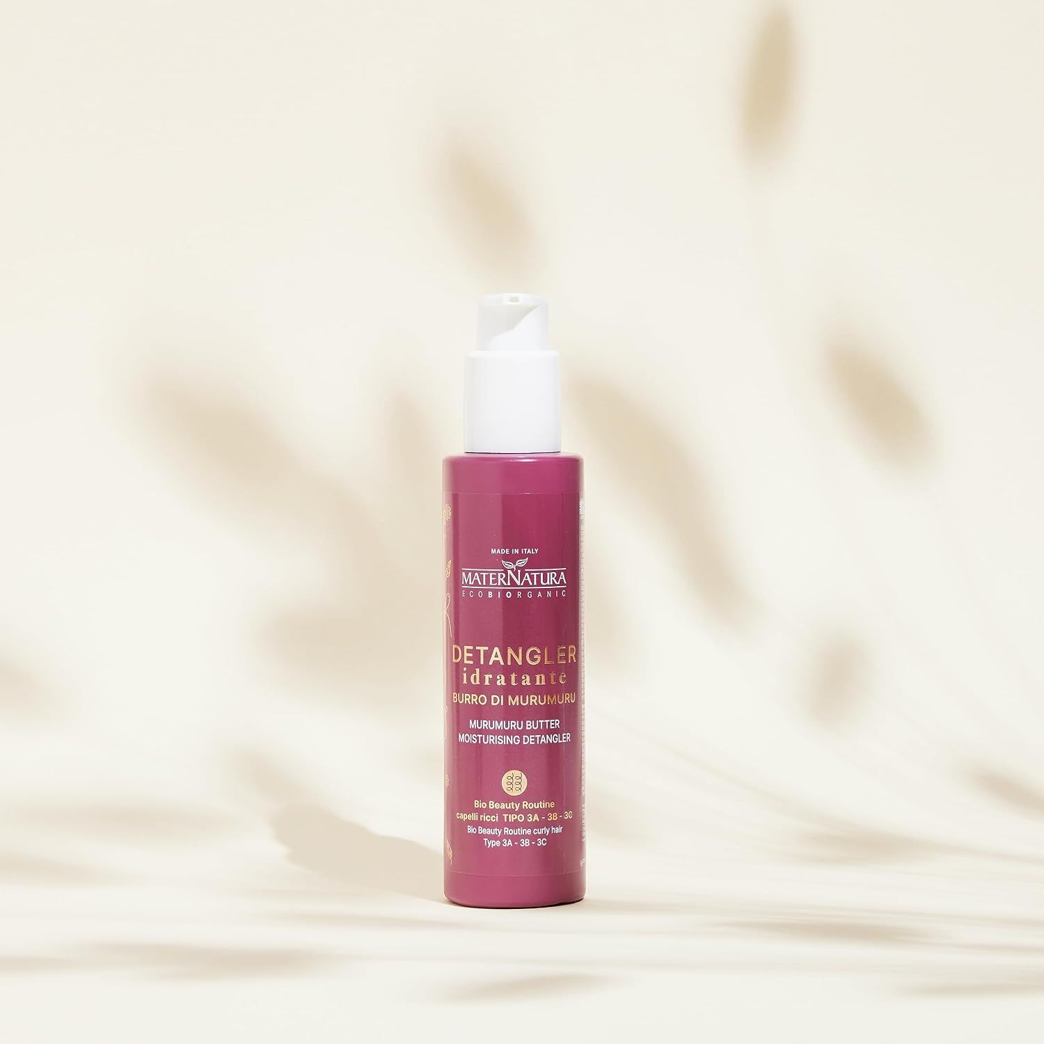 Eine rosa Flasche mit einem Pumpspender, die als entwirrender Feuchtigkeitsspray mit Murumuru-Butter gekennzeichnet ist.
